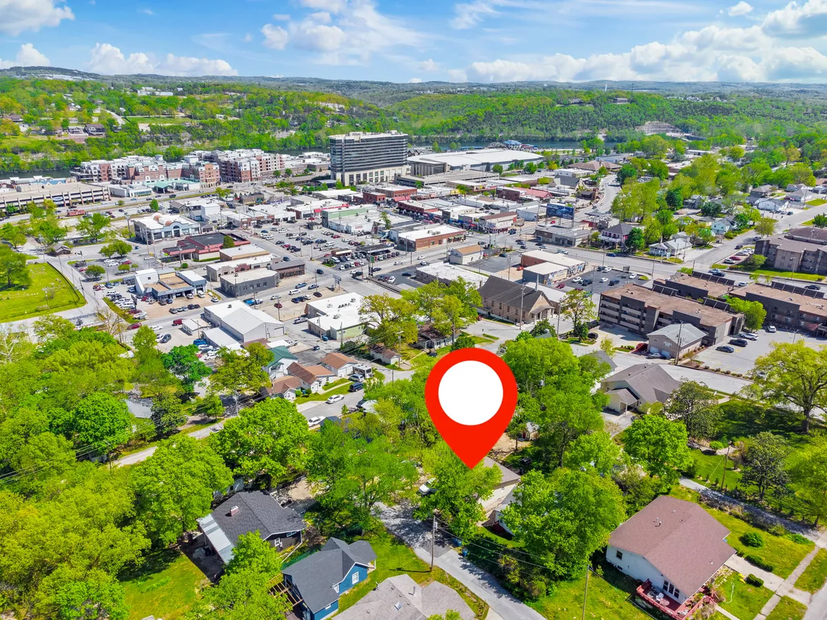 A wide view of Branson's downtown area, including green spaces, residential neighborhoods, and commercial buildings. The scene shows how downtown is interconnected with parks and community gathering spots, offering both urban excitement and areas for relaxation.