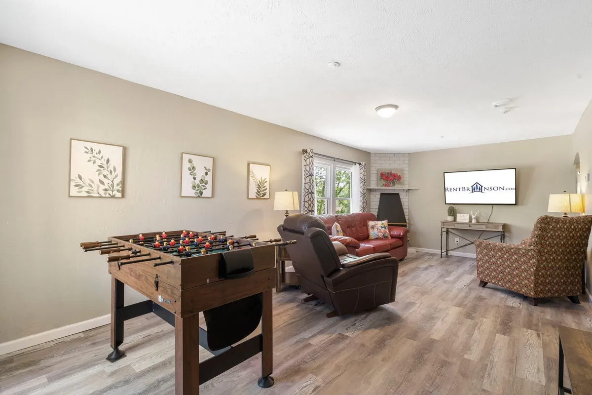 A relaxed living area with a foosball table, recliner, TV, and decorative wall art. The scene buzzes with the potential for friendly group games, movie nights, and laid-back conversations.